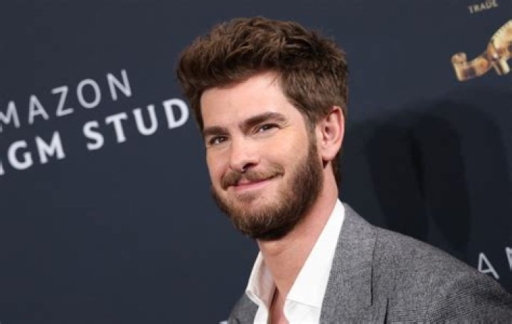 Andrew Garfield, a part of the 'Spider-Man: No Way Home' cast, wears a light blue suit over a light blue button-up shirt.