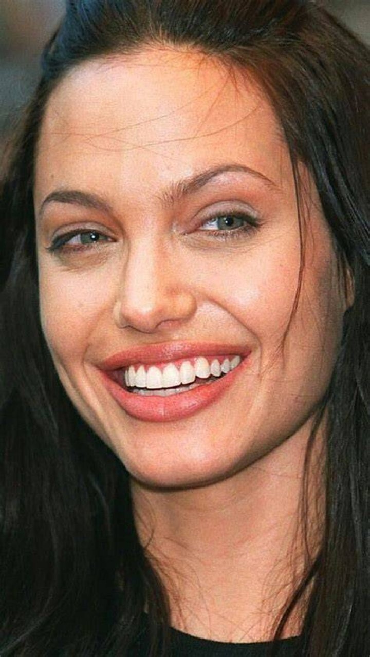 Angelina Jolie smiling in a black dress.