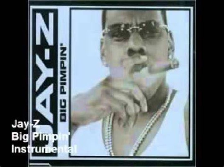 Jay-Z, rapped behind Big Pimpin with Pimp C, wearing a black T-shirt against a green backdrop