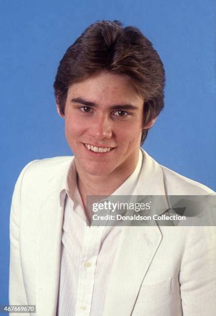 Jim Carrey posing at the premiere of 'Sonic' in a red blazer.