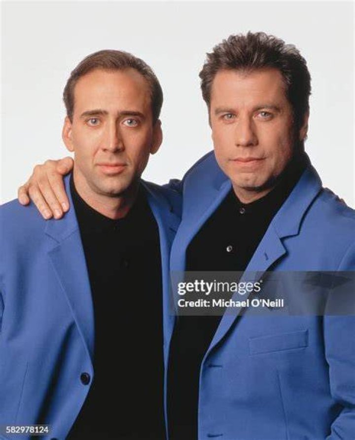 John Travolta and Nicolas Cage point guns at each other