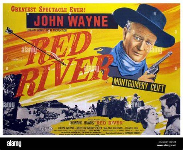 John Wayne starring in one of his Western movies. He's wearing a Western costume and cowboy hat in a black-and-white photo. He's riding a horse.