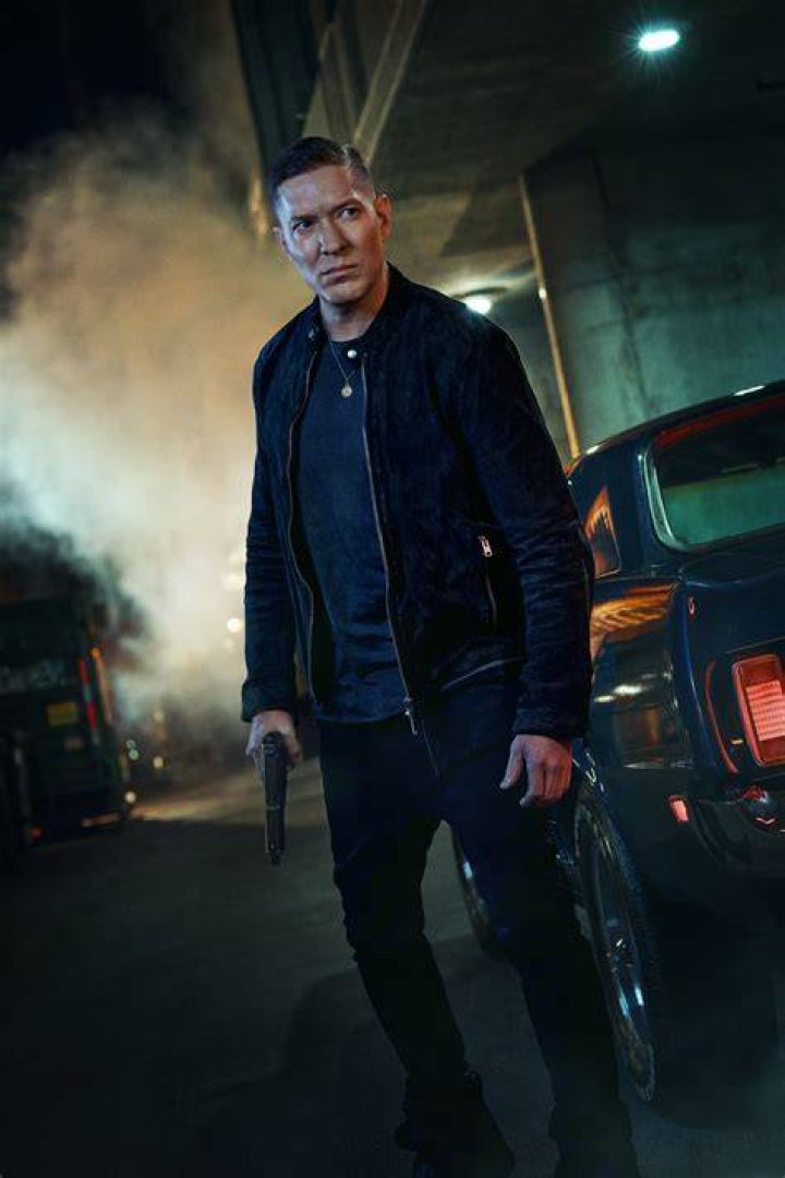Joseph Sikora as Tommy Egan holding two huge bags of money in 'Power Book IV: Force'