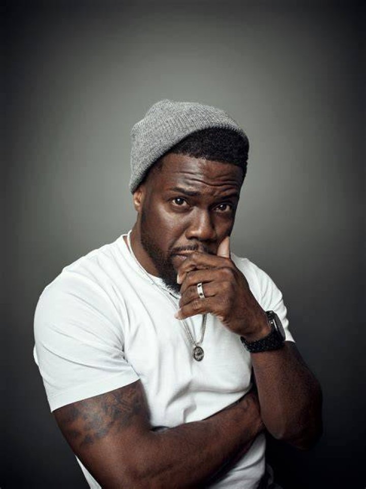 Kevin hart posing in a grey shirt at Sirius XM.