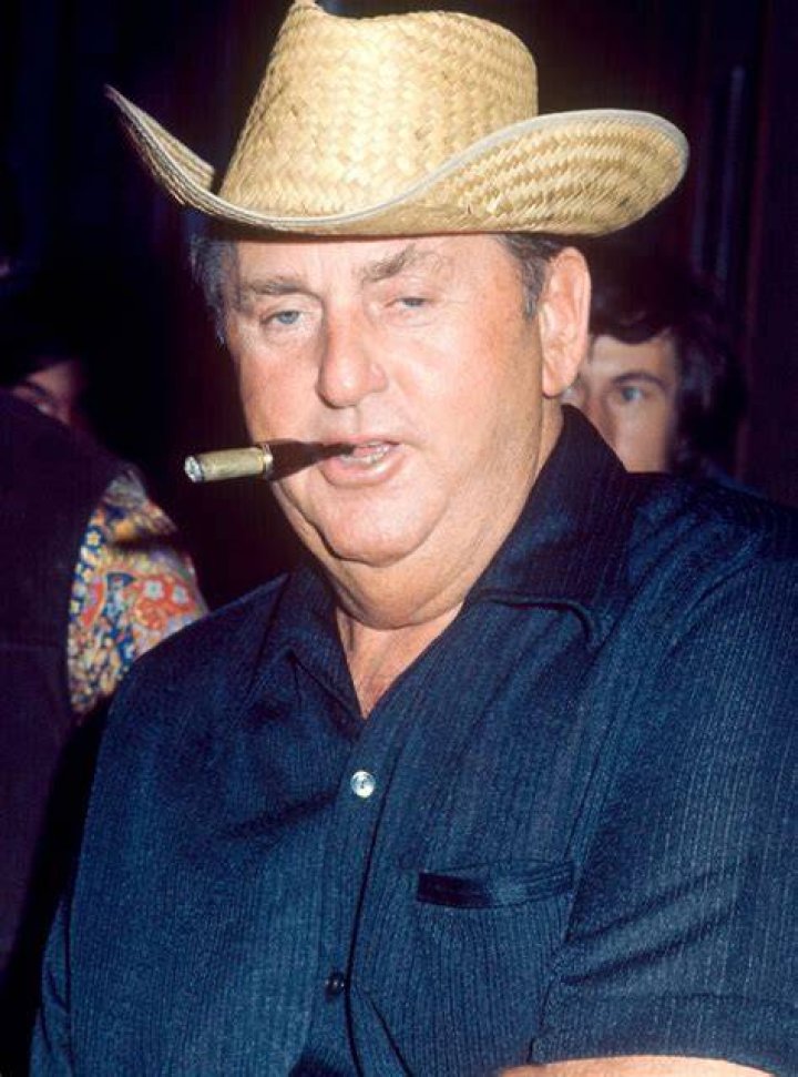 (L-R) Colonel Tom Parker, smoking a pipe, and Elvis Presley smiling
