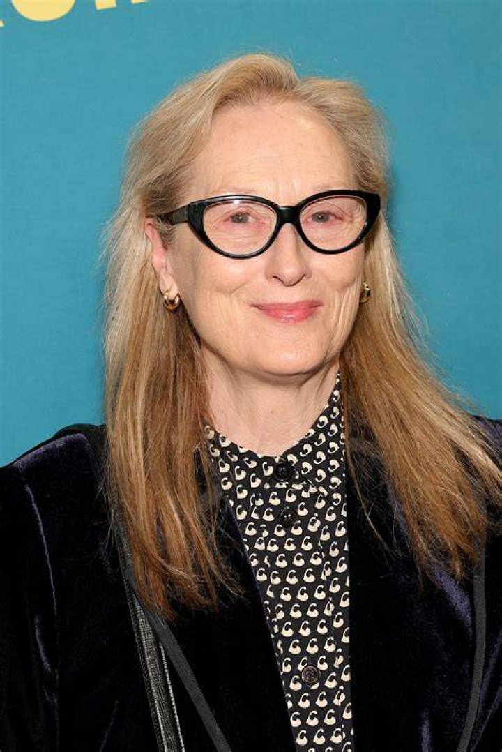 Meryl Streep smiling in front of a blurred crowd