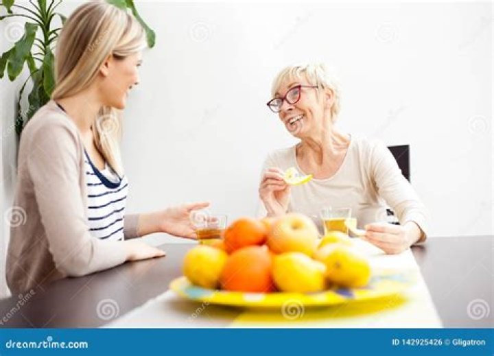 Senior mother and daughter drinking coffee together at home