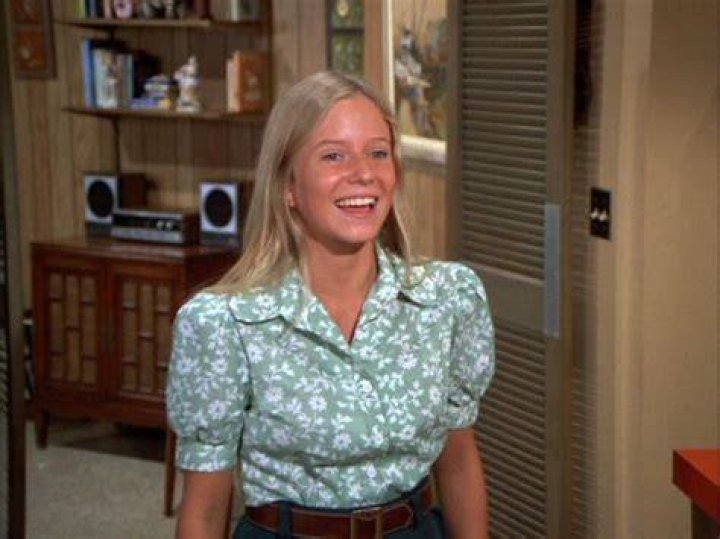 Smiling Eve Plumb as Jan Brady in 'The Brady Bunch' and as an adult with short hair in a green shirt
