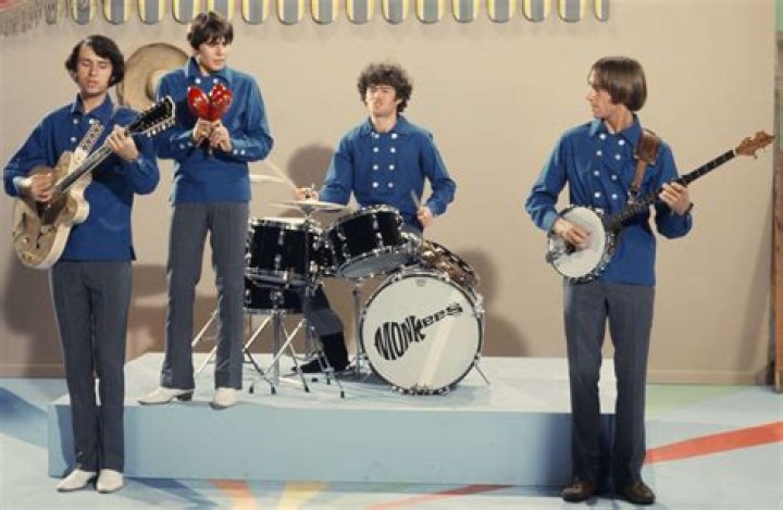 The Monkees' Peter Tork, Davy Jones, Mike Nesmith, and Micky Dolenz near a piano